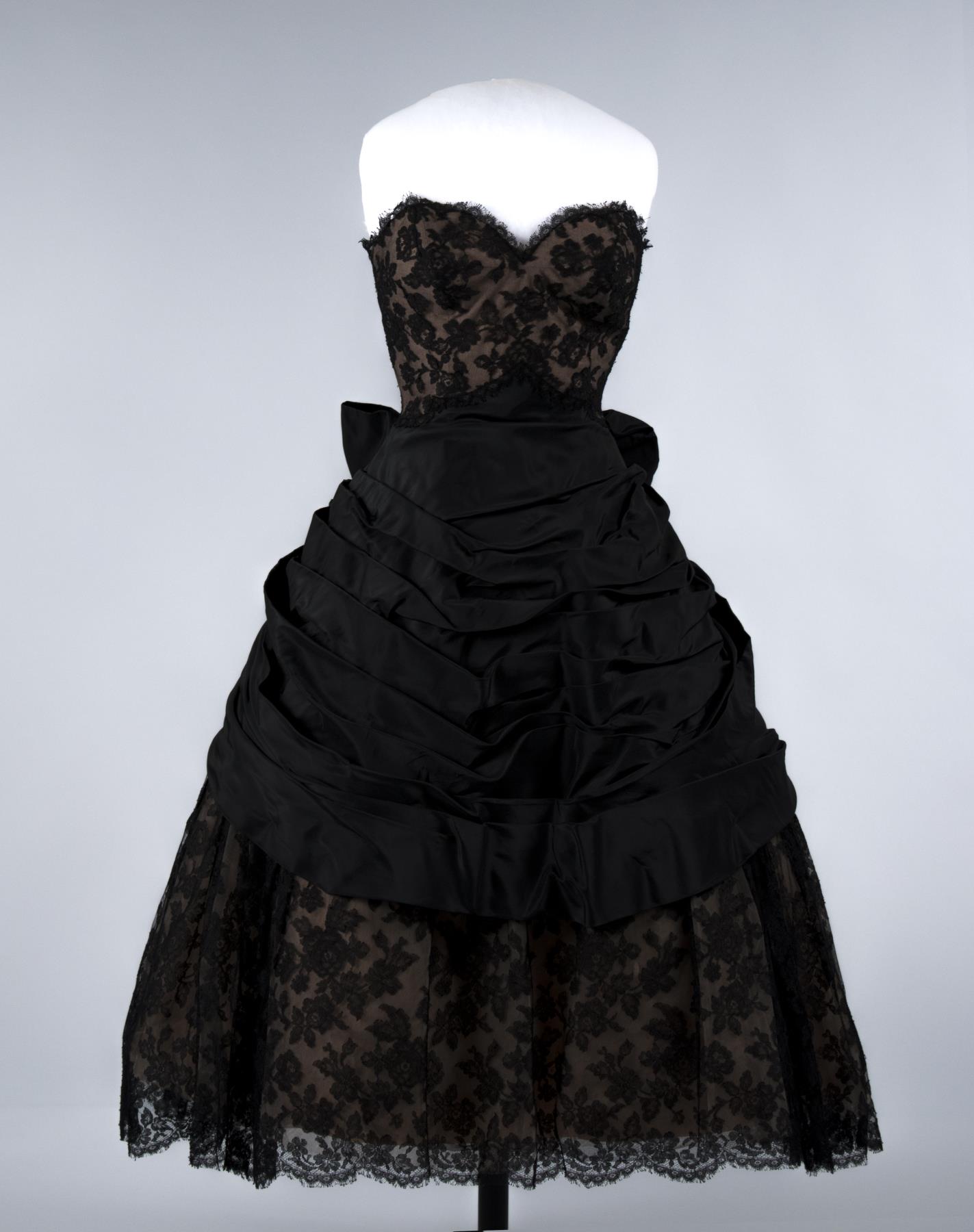 Image of Woman's black lace evening gown, over pink-orange taffeta, 1957